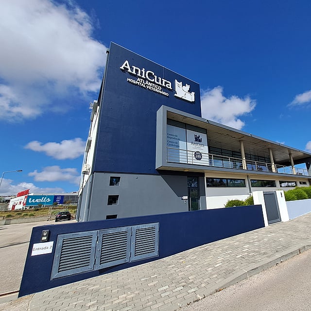 Um edifício com uma parede azul e um céu azul com nuvens.